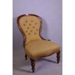 A Victorian walnut balloon back nursing chair with button back upholstery, raised on turned supports