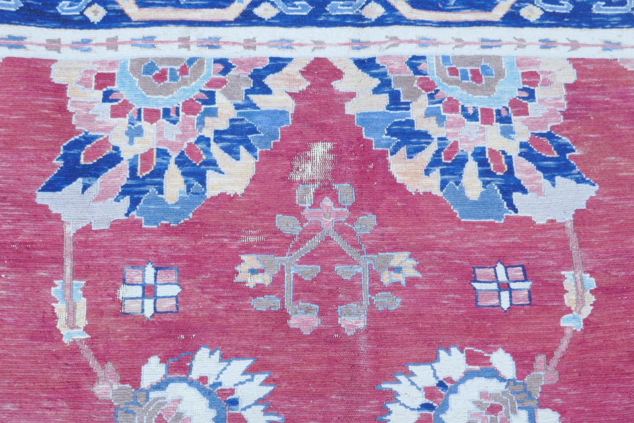 A Middle Eastern hand woven wool carpet with stylised floral designs on a faded red field, 320 x - Image 8 of 9