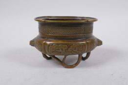 A Chinese bronze censer with two mask handles and bamboo tripod supports, 13 x 9cm x 8cm high