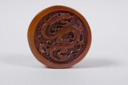 A Chinese amber soapstone cylinder seal, with dragon decoration to the top, 6cm diameter