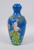 A Chinese blue ground porcelain garlic head shaped vase with raised and painted red crowned crane