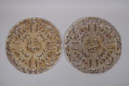 A pair of late C19th/early C20th Chinese carved and pierced hardstone pi-discs, with archaic