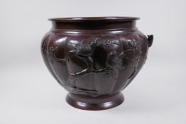 A Japanese Meiji period bronze planter with embossed and applied decoration of birds on fruiting