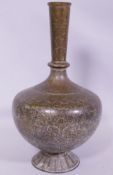 An antique Indian brass vase with engraved decoration of scrolling foliate designs and figures