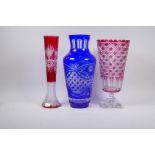 An overlaid and flash cut ruby glass stem vase with star cut bases, 35cm high and a Bohemian blue