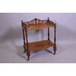 A Victorian walnut two tier occasional table, with carved and pierced three quarter gallery top