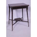 An Edwardian mahogany card table with fold over top, raised on splay supports united by an