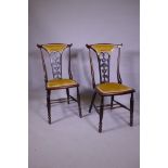 A pair of Art Nouveau stained beechwood side chairs with carved and pierced backs, raised on