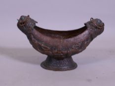 An Eastern/Tibetan copper kashkul vessel with repousse decoration of serpents and fantastic