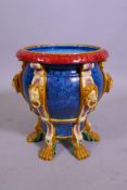 A Majolica glazed planter with lion mask decoration, raised on six paw feet, 29cm diameter, 30cm