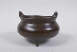 A Chinese bronze censer on tripod supports with two phoenix eye handles, 10cm diameter, 4