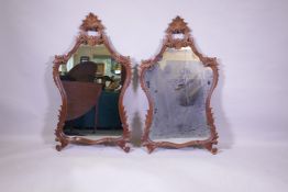 A pair of rococo style carved and pierced walnut wall mirrors, AF minor losses, 62 x 110cm