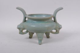 A Chinese Ru ware style porcelain two handled censer on tripod supports, with dragon mask
