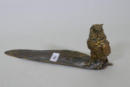 A bronzed metal pen tray in the form of a feather with owl inkwell, lacks liner, 34cm long