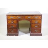 Early C19th figured mahogany kneehole desk, eight drawers with oak linings, and inset leather top,