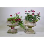 A pair of reconstituted stone garden urns, 38cm high