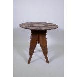 An antique Indian carved hardwood occasional table with lotus flower and lily pad decoration, 60cm