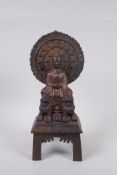 A Sino Tibetan bronze Buddha seated upon fo-dogs, with remnants of gilt patina, 29cm high