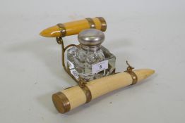 A Victorian inkwell with brass mounted faux ivory tusks, 24 x 12cm