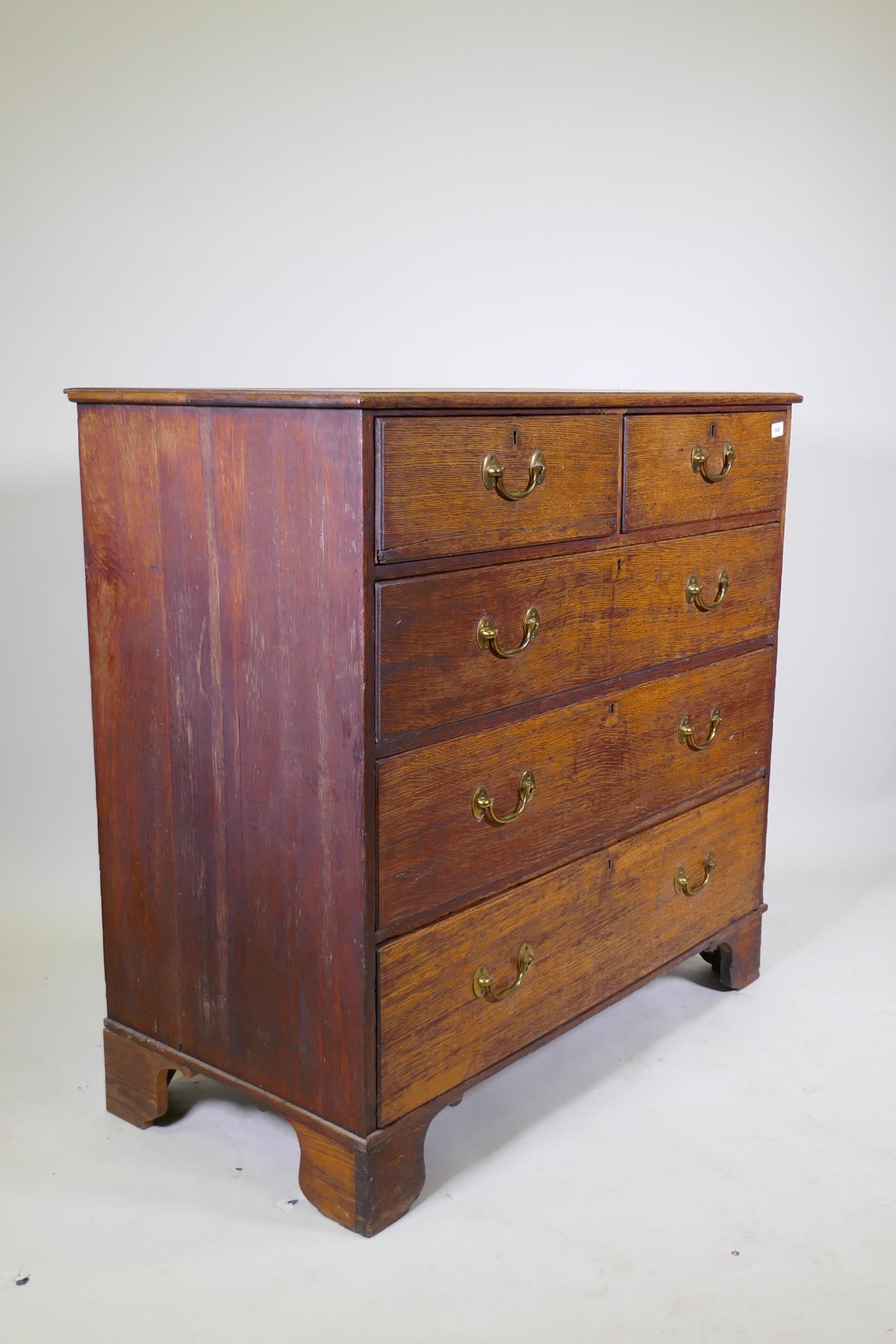 A George III oak chest of two over three drawers with brass handles, raised on bracket supports, 110 - Image 4 of 4
