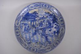 A Chinese blue and white porcelain charger decorated with ladies in a garden, with flower and