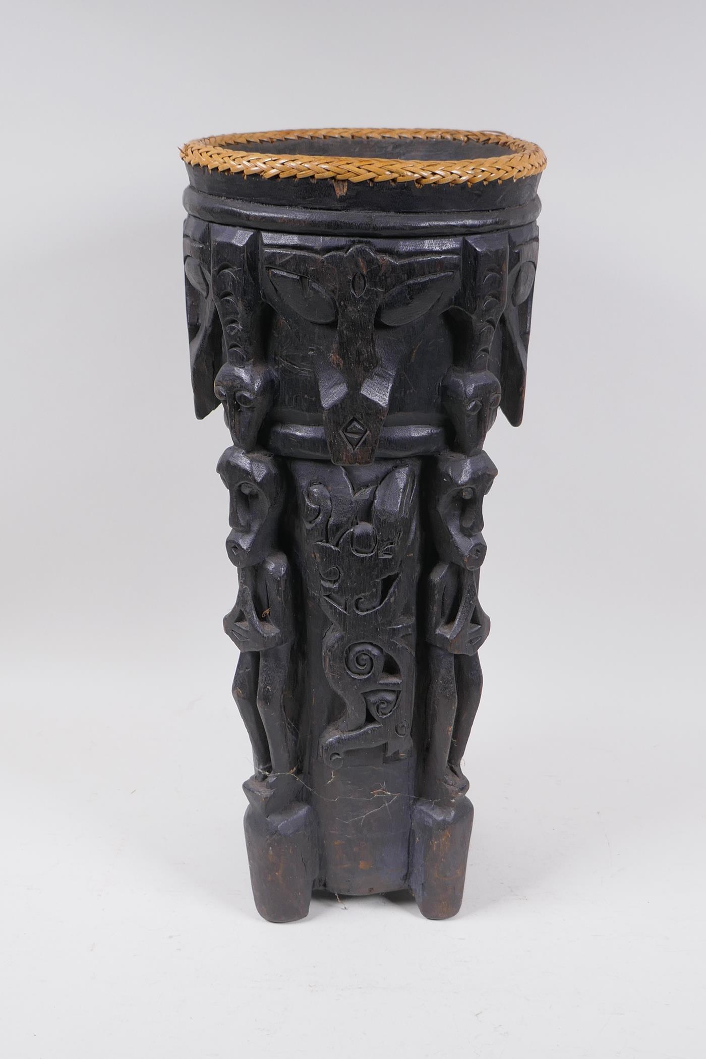 An Indonesian Dayak tribal carved and ebonised wood stick stand with figural and animal