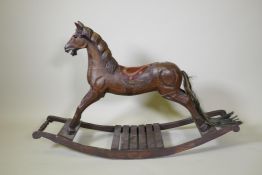 A vintage carved and painted wood rocking horse on a sleigh base, 123cm long
