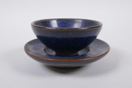 A Chinese Jian ware tea bowl and saucer with a speckled blue glaze, character marks to base, bowl
