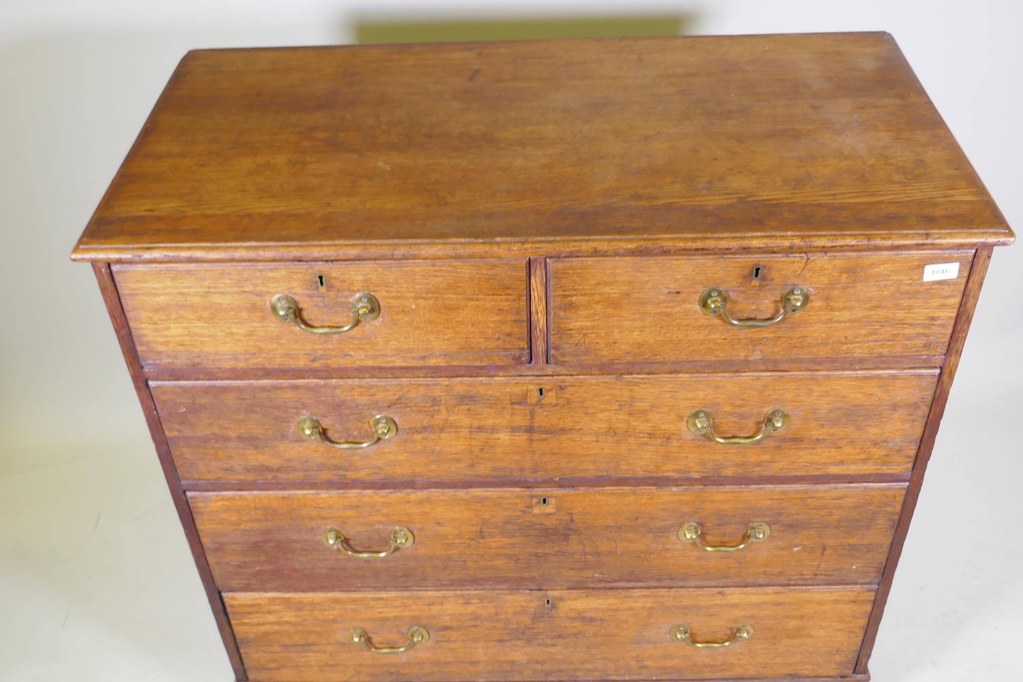 A George III oak chest of two over three drawers with brass handles, raised on bracket supports, 110 - Image 3 of 4