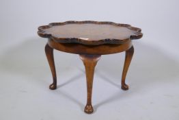 A 1930s walnut coffee table with moulded dish top and cabriole supports, 54cm diameter, 35cm high