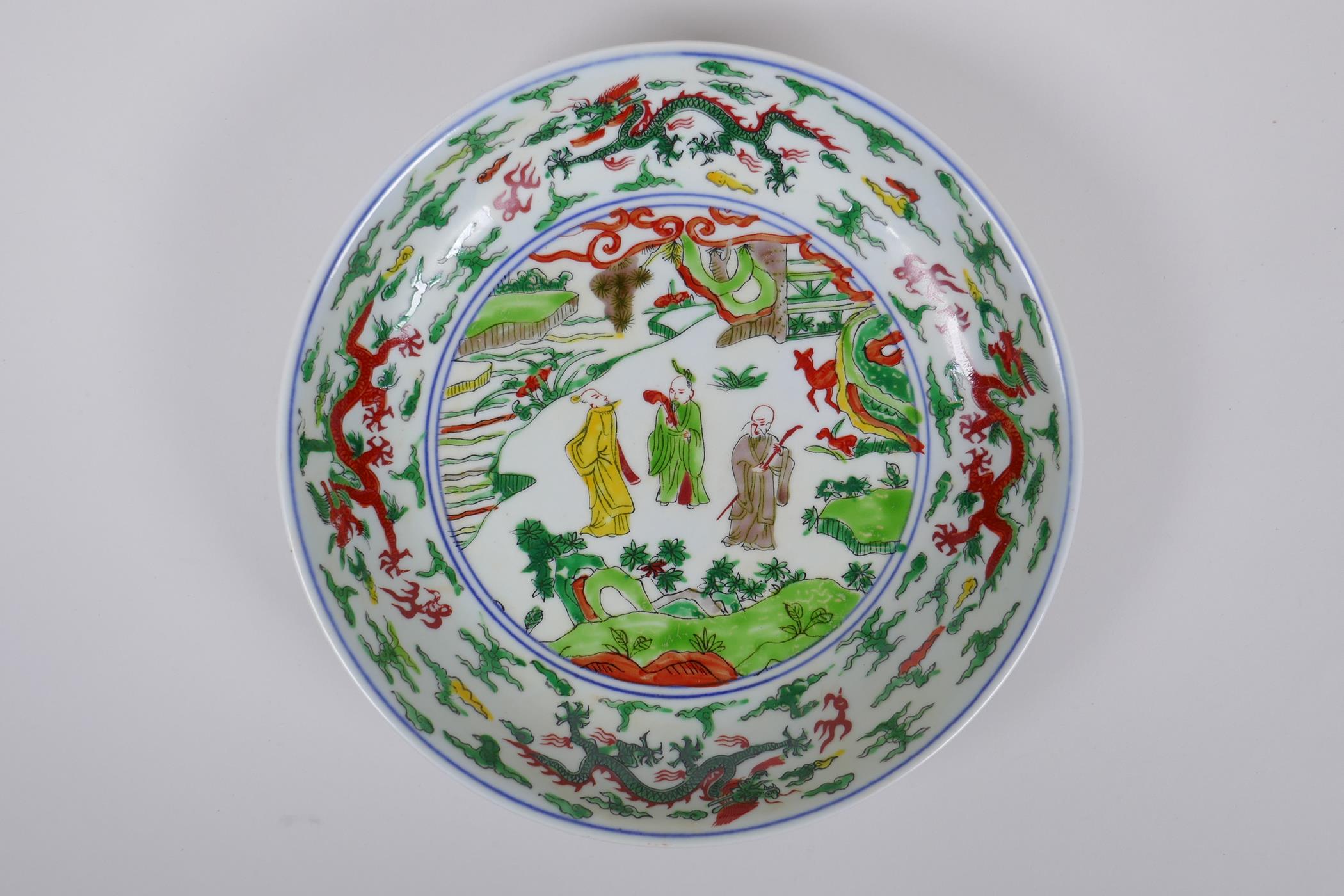 A Chinese Wucai porcelain dish decorated with figures in a landscape, Wanli 6 character mark to