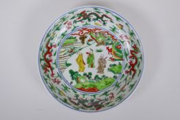 A Chinese Wucai porcelain dish decorated with figures in a landscape, Wanli 6 character mark to