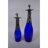 Two blue glass decanters with silver plated vine leaf decoration and stopper, largest 35cm high