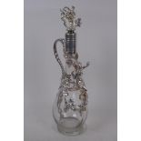 A clear glass and silver plate claret decanter decorated with vine leaves and a female