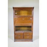 An early C20th American Gunn four section bookcase, one section fitted as a fall front secretaire,