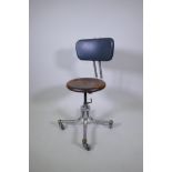 An industrial metal tubular, adjustable office chair with a wood seat