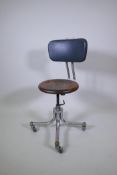An industrial metal tubular, adjustable office chair with a wood seat