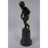 A bronze figure of Cupid delivering love letters,  raised on a turned marble socle, 28cm high