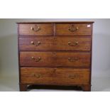 A George III oak chest of two over three drawers with brass handles, raised on bracket supports, 110