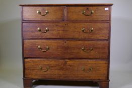 A George III oak chest of two over three drawers with brass handles, raised on bracket supports, 110