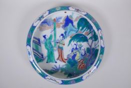 A famille vert porcelain dish with a rolled rim, decorated with figures in a garden, Chinese