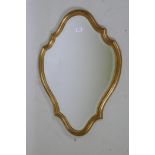 A shaped giltwood wall mirror with bevelled glass, 74 x 53cm