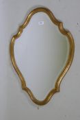 A shaped giltwood wall mirror with bevelled glass, 74 x 53cm