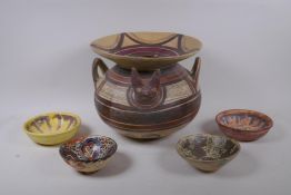 A middle eastern terracotta pot with geometric decoration, and four terracotta bowls with Islamic