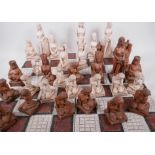 A part chess set, the pieces resin cast as female nudes, largest 19cm high, with a four piece tile