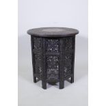 A C19th Anglo Indian occasional table with carved scrolling decoration and inset top with brass vine