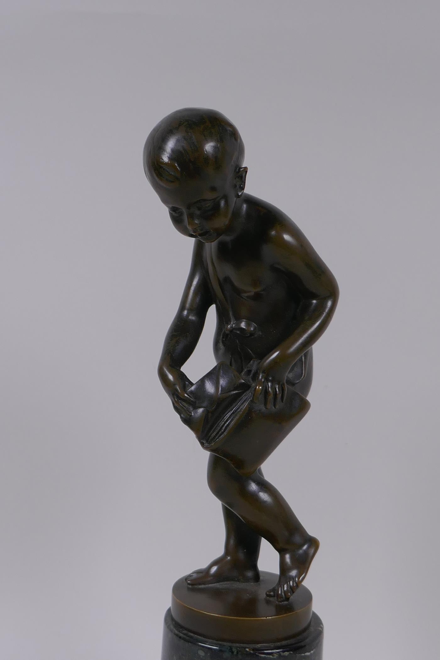 A bronze figure of Cupid delivering love letters,  raised on a turned marble socle, 28cm high - Image 2 of 5