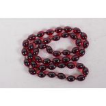 A string of faux cherry amber beads, 85cm long