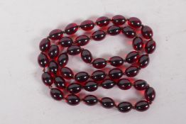 A string of faux cherry amber beads, 85cm long