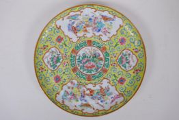 A C19th famille jaune Canton enamelled porcelain cabinet plate, with decorative panels depicting